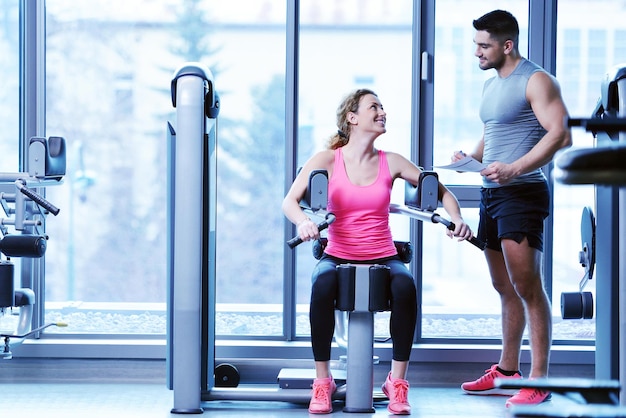 Femme de gym faisant de l'exercice avec son entraîneur personnel