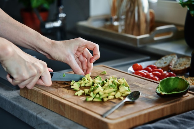 Femme hacher l'avocat pour les toasts du petit déjeuner