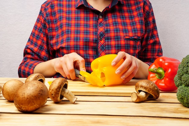 Femme hacher des légumes dans la cuisine.