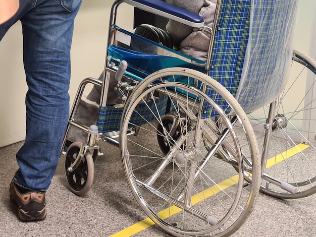 Une femme handicapée est assise dans un fauteuil roulant et tient le gros plan de la roue