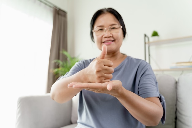 Femme handicapée sourde asiatique mature utilisant la langue des signes pour communiquer avec d'autres personnes.