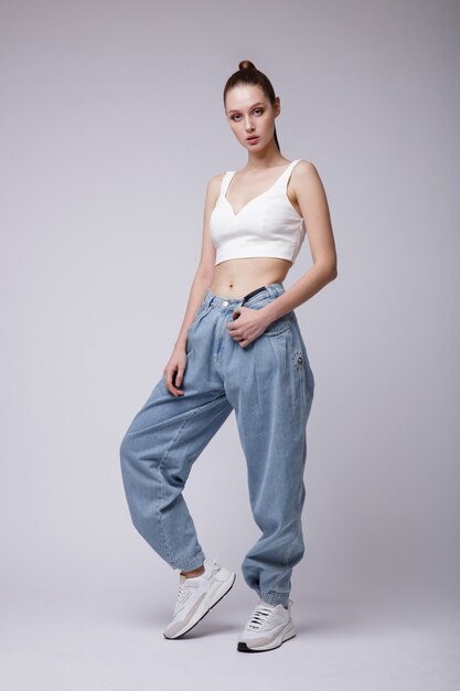 Femme en haut blanc baskets jeans bleu sur fond blanc Studio Shot