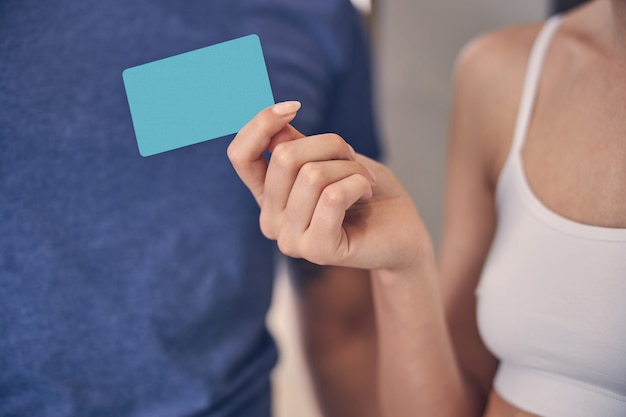 femme en haut blanc gardant avec les doigts objet en plastique