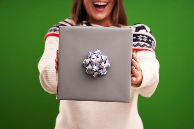 Femme heureuse adulte avec cadeau de Noël sur fond vert