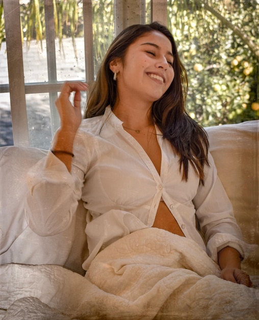 Une femme heureuse assise sur le canapé à la maison.