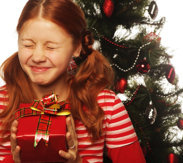 Femme heureuse avec boîte-cadeau et arbre de Noël