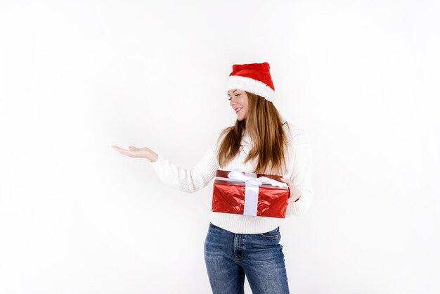 Photo femme heureuse avec une boîte à cadeaux de noël isolée sur fond blanc portant un chapeau de père noël