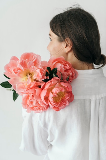 Femme heureuse avec un bouquet de pivoine coucher de soleil corail