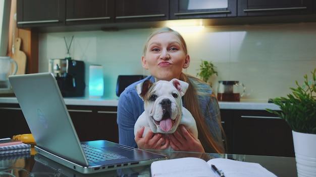 Femme heureuse avec un bulldog regardant la caméra et souriant