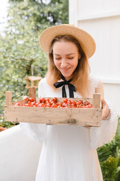 Femme heureuse, à, cerises, porter, chapeau, et, robe blanche