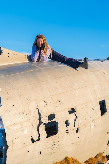 Une femme heureuse dans l'avion à Solheimasandur souriant pendant ses vacances en Islande