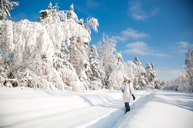 Femme heureuse dans la forêt d'hiver enneigée