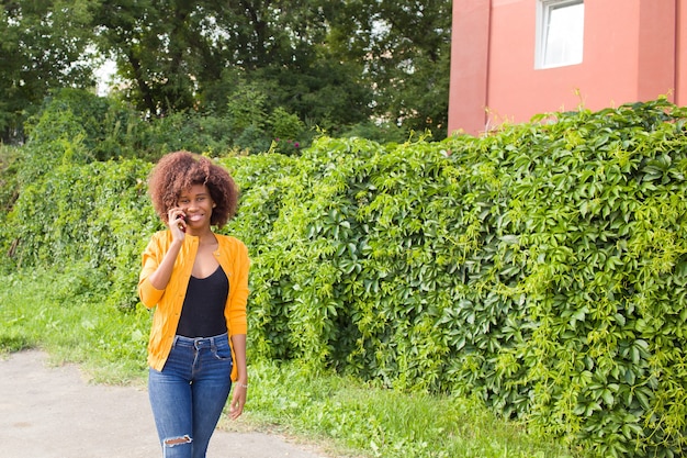 La femme heureuse dans la rue, parler au téléphone