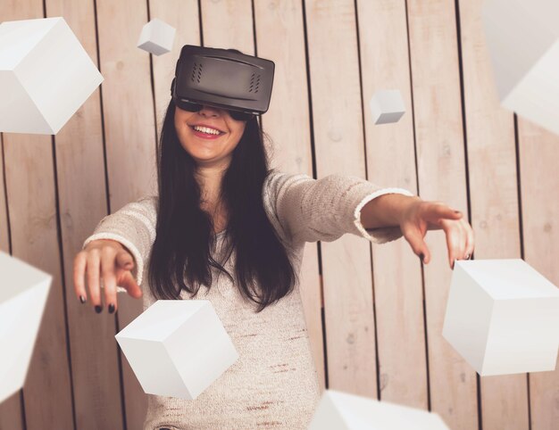Femme heureuse dans des verres de VR avec des objets 3d autour