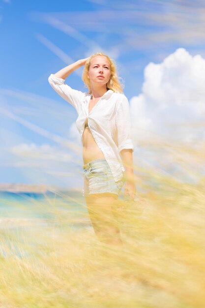 Photo une femme heureuse debout sur le champ contre le ciel