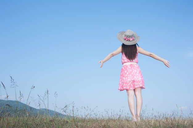 Femme heureuse debout avec le ciel bleu