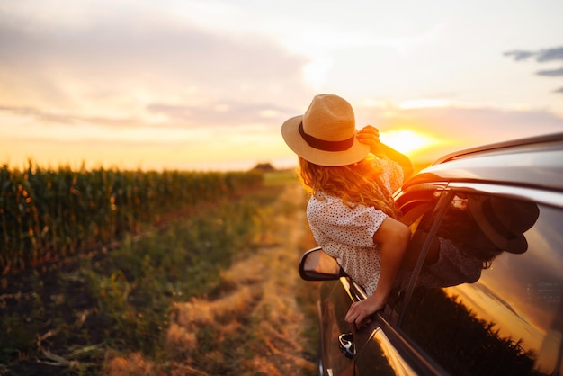 Femme heureuse détendue sur la route d'été voyage vacances se penchant par la fenêtre de la voiture