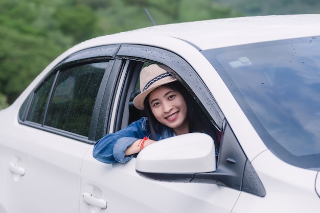 Femme heureuse détendue sur les vacances de voyage été route voyage regardant la nature vue par la fenêtre de la voiture