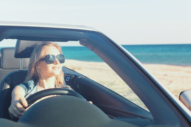 Femme heureuse détendue voyageant dans une voiture