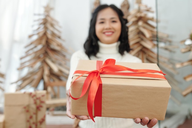 Femme heureuse donnant l'accent sur le présent de Noël fort