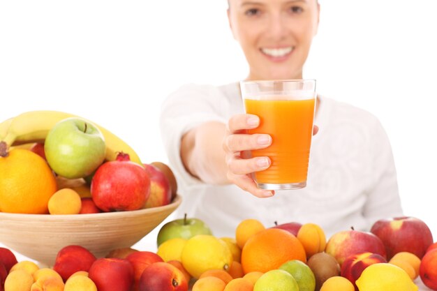 une femme heureuse avec du jus de fruits sur fond blanc