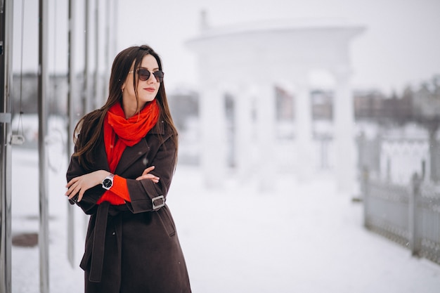 Femme heureuse en écharpe rouge en hiver à l&#39;extérieur