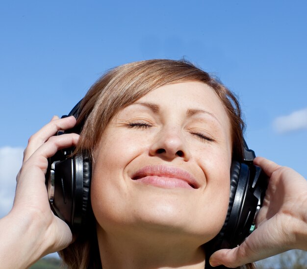 Femme heureuse écoute de la musique en plein air