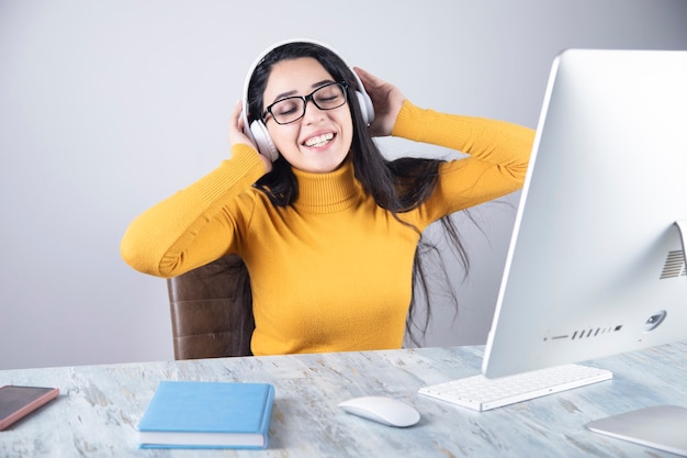 Femme heureuse, écouter de la musique avec des écouteurs et un ordinateur