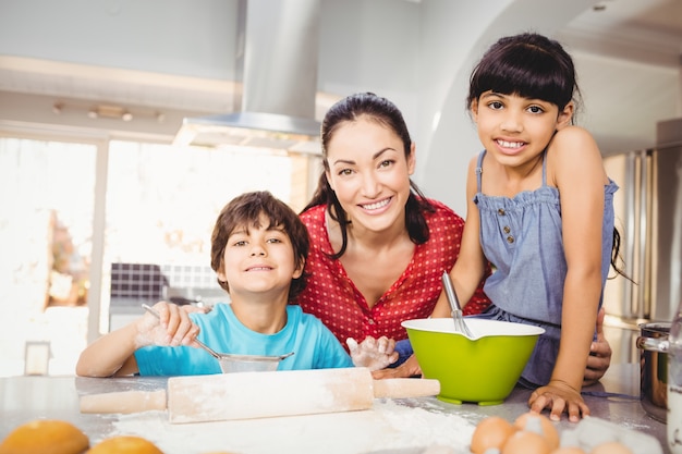 Femme heureuse avec des enfants préparant un repas à la maison