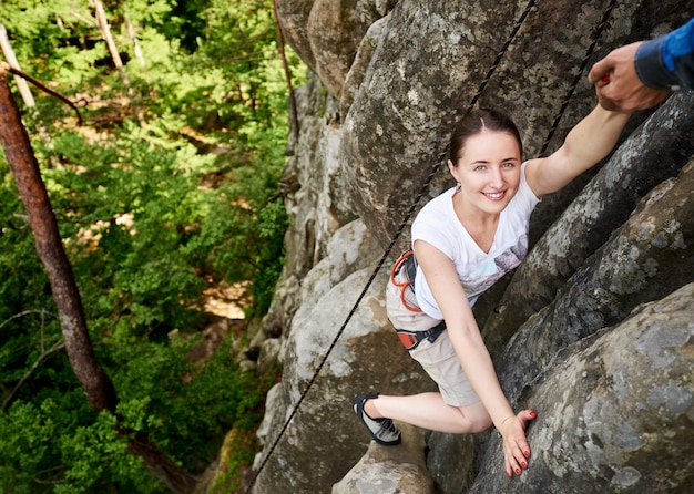 Femme heureuse escalade rock trekking à l'extérieur. Randonneur insouciant souriant à son amie. Homme, portion, escalade, rocher