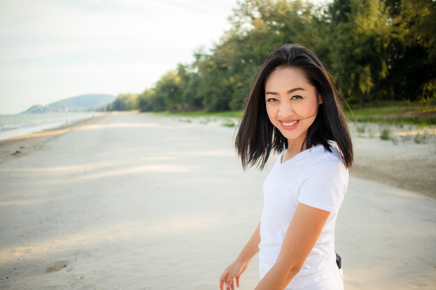 Femme heureuse faire une promenade sur la plage.