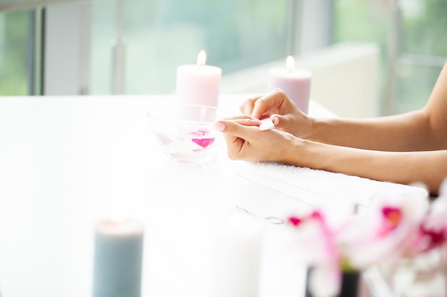 Femme heureuse faisant la manucure en se reposant à la maison