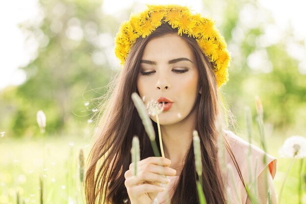 Femme heureuse avec des fleurs de pissenlit à l'extérieur