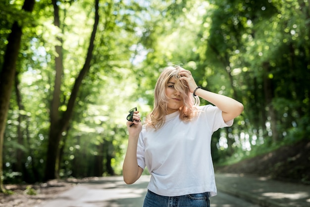 Une femme heureuse en forêt profite de l'heure d'été gratuite sur fond de bois