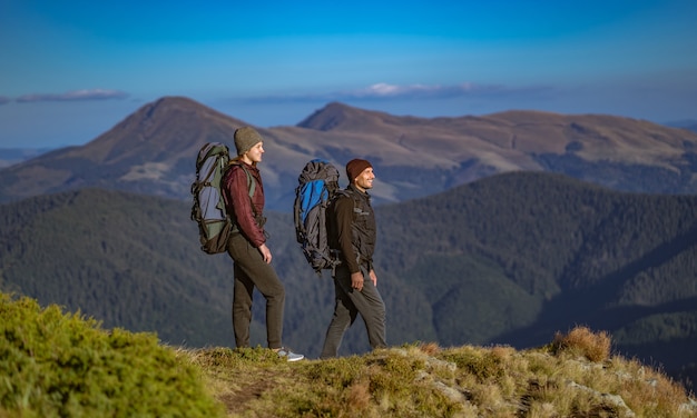 La femme heureuse et un homme marchant sur la montagne