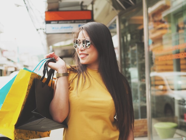 Femme heureuse joyeuse avec shopping dans la rue