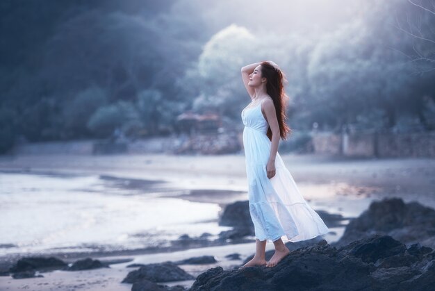 Femme heureuse libre sur la plage, profitant de la nature.