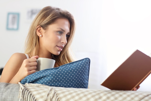 femme heureuse lisant sur un canapé