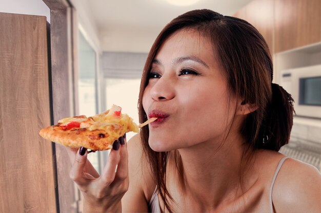 Femme heureuse, manger une pizza savoureuse.