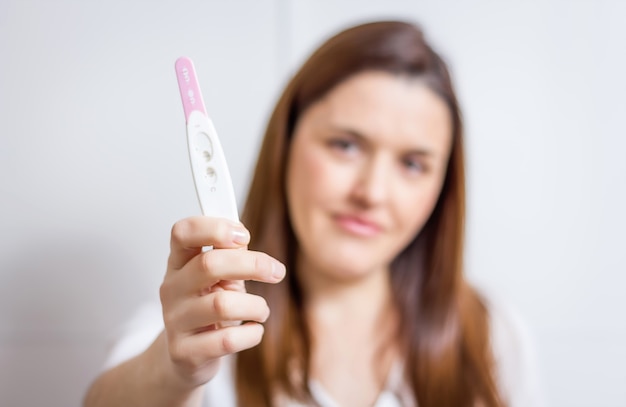 Femme heureuse montrant son test de grossesse positif