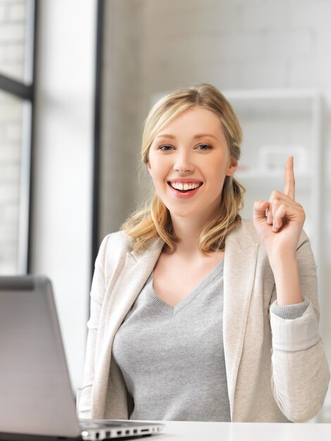 femme heureuse avec ordinateur portable et doigt vers le haut