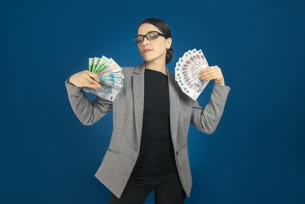 Photo femme heureuse avec un paquet de tenge du kazakhstan et de roubles russes dans sa main mise au point sélective