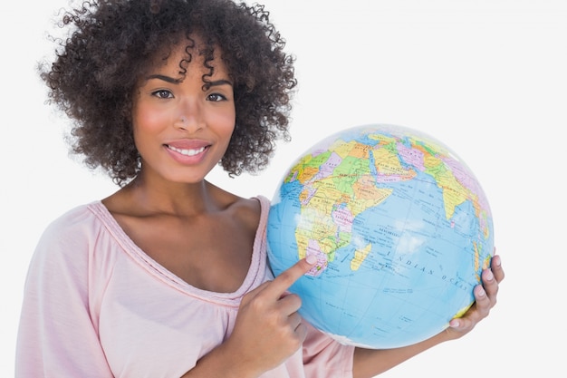 Femme heureuse pointant vers le globe