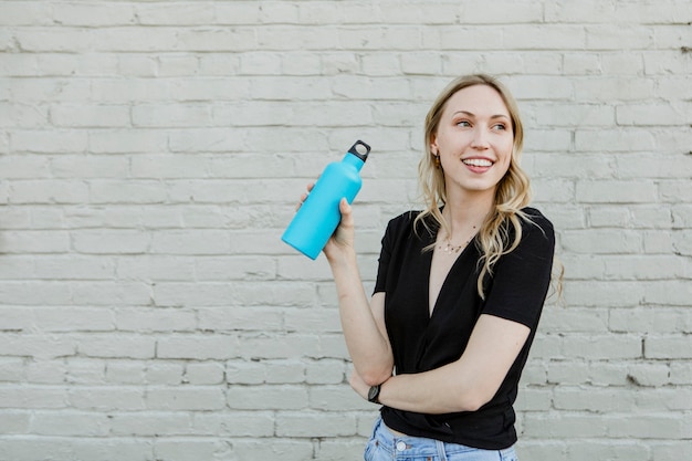 Femme heureuse portant une bouteille thermique