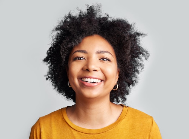 Femme heureuse et portrait confiant en studio fond blanc et toile de fond Visage de jeune modèle féminin sourire et cheveux afro bouclés naturels avec personnalité positive gen z et fille d'Afrique du Sud