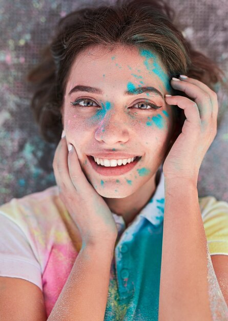 Photo femme heureuse avec de la poudre holi sur le visage