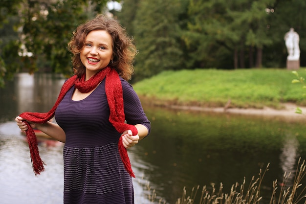 Femme heureuse près de la rivière en saison d'automne