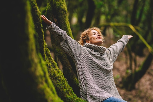 Femme heureuse ravie profitant de la belle forêt verte des bois de la nature autour d'elle