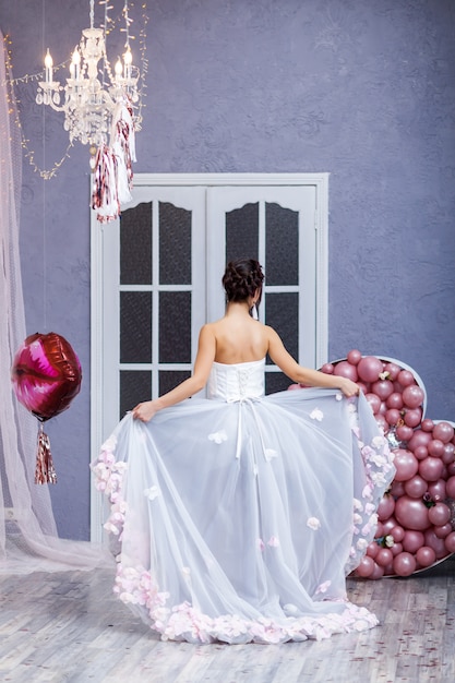 Femme heureuse en robe de tulle avec des ballons roses. luxe