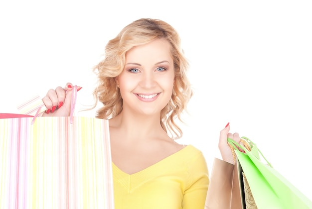 femme heureuse avec des sacs à provisions sur blanc